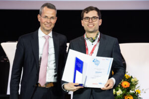 Award winner Dr.-Ing. Moritz Joseph holds a certificate and stands next to Professor Malte Brettel.