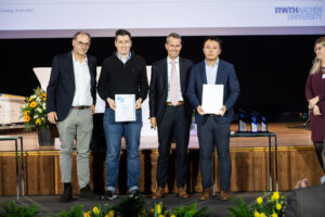 Professor Heinz Pitsch, Mathis Bode, Professor Malte Brettel and Weihan Li from left standing on the stage of the award ceremony.