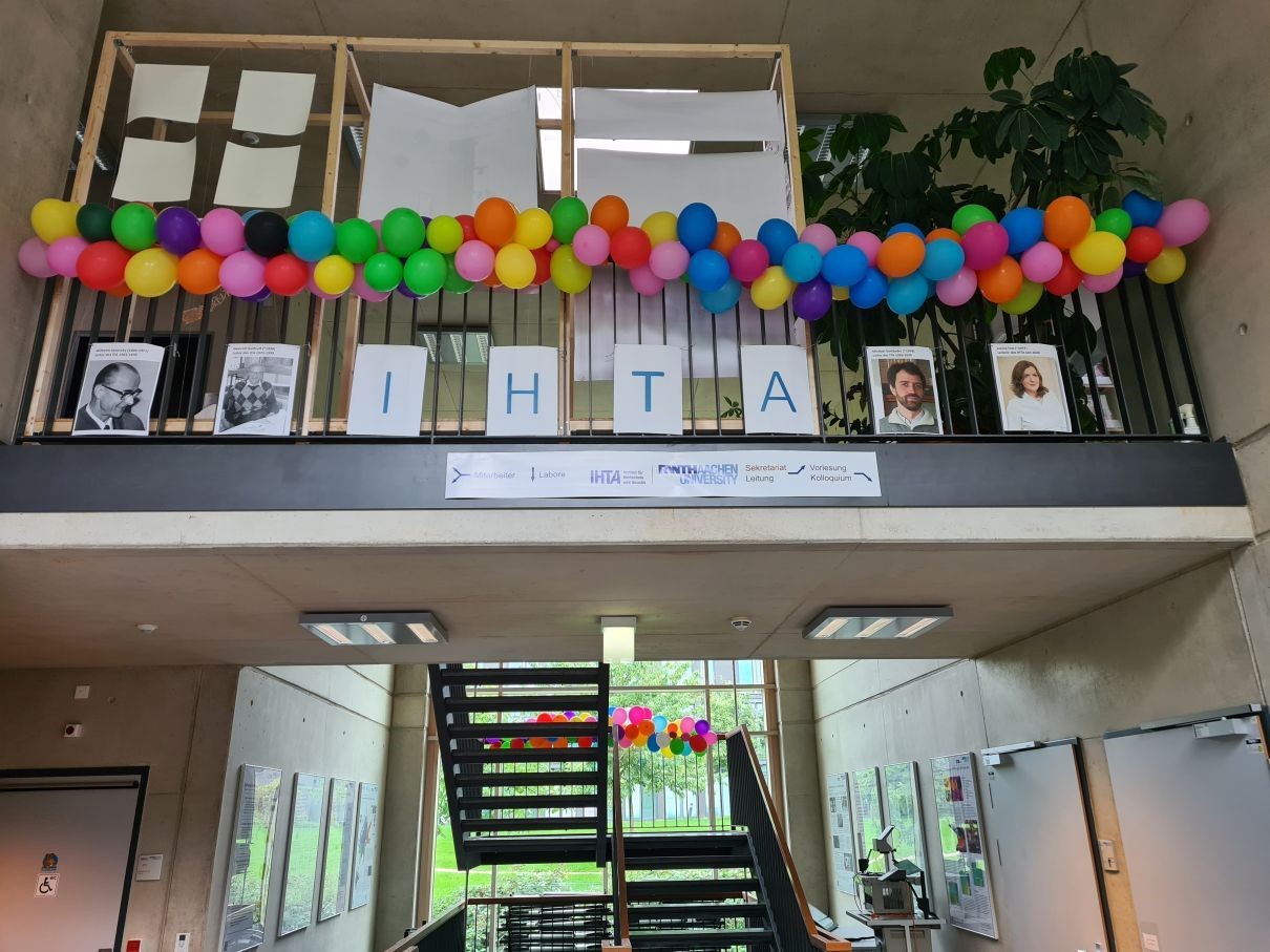 Staircase festively decorated with balloons and photographs of current and historical persons of the Institute's management.