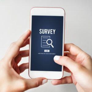 Two hands holding a smartphone that displays a survey