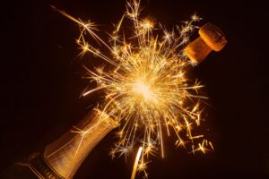 Champagne bottle with cork and lit fireworks