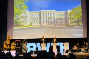 Auf der Bühne der RWTHtransparent-Veranstaltung stehen der Rektor und Kanzler