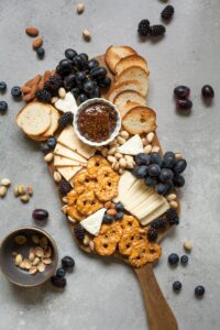 Charcuterie board with grapes, different cheeses and crackers