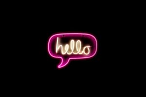 Neon tubes forming the word “hello" in a speech bubble
