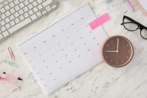 Flacher Schreibtischkalender und eine Uhr
