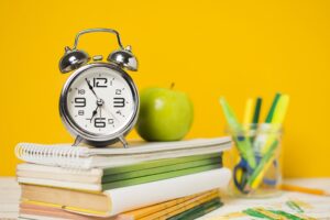 Clock and apple on school books