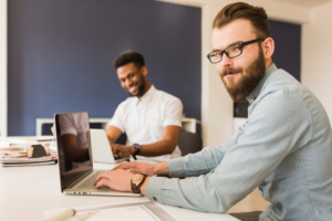 Two men with laptops in the office