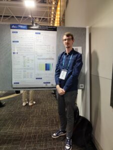 A person stands in front of a scientific poster.