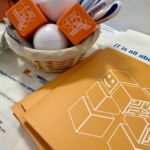 IT Center Merchandise, darunter Stressbälle, Mappen und Kugelschreiber.