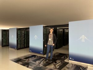 A person stands in front of the Fugaku supercomputer