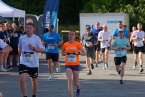 A group of runners wearing race numbers at a company run