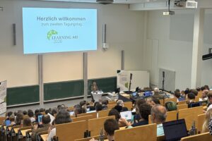 Lecture Hall with presentation "Herzlich Willkommen zum zweiten Tagungstag Learning AID 2026"